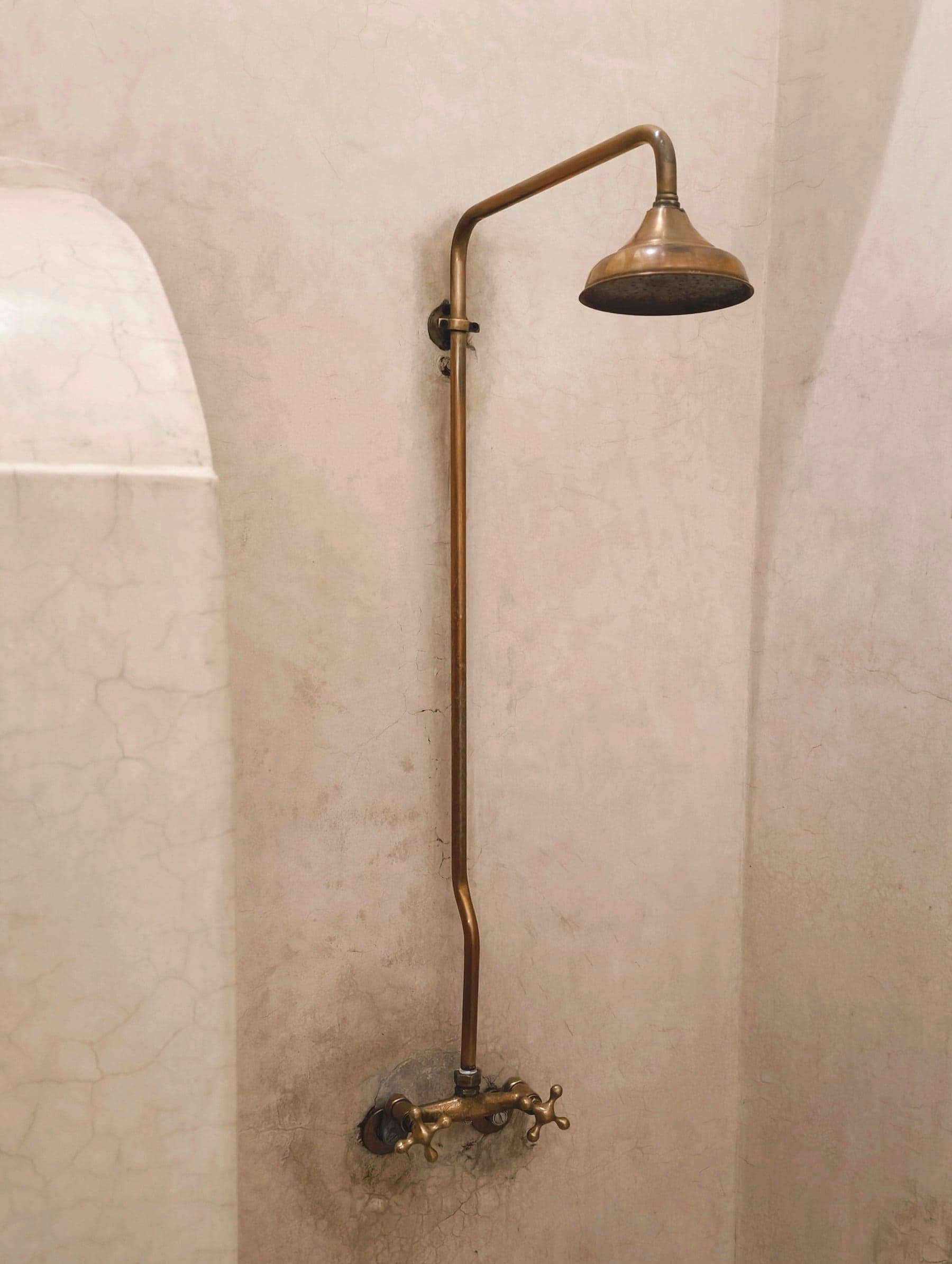 Arched shower alcove in hand-applied lime plaster with brass fittings