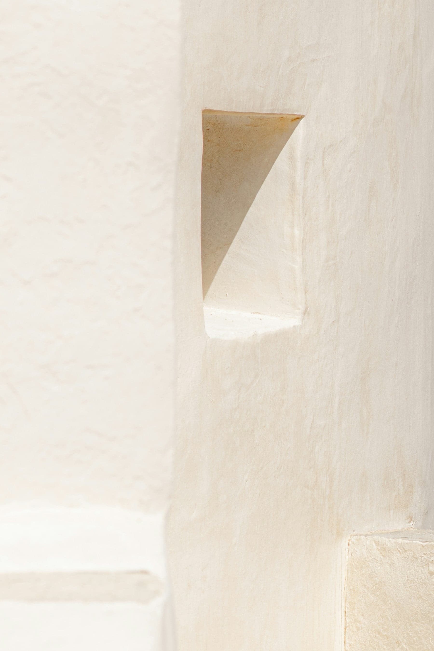 Detail of a small niche carved into a soft white lime-plaster wall